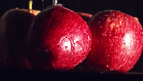 Close-up,-water-droplets-splashing-on-red-apples