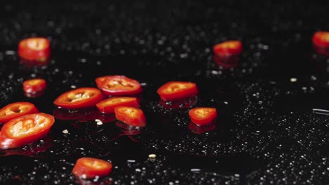 red chili slices on a black background