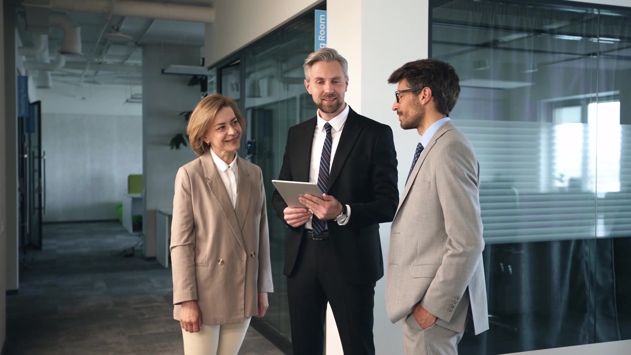 Business People Discussing Project on Digital Tablet in Modern Office