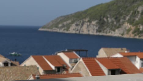 Hand-lifting-juice-glass-in-morning-on-balcony,-Mediterranean-seaside-town