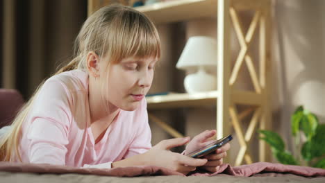 Seitenansicht-Des-Kindes,-Wie-Es-Sich-In-Seinem-Zimmer-Ausruht-Und-Ein-Smartphone-Benutzt