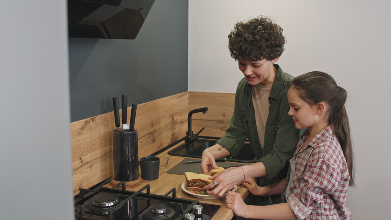 Mother And Little Daughter Making Sandwiches