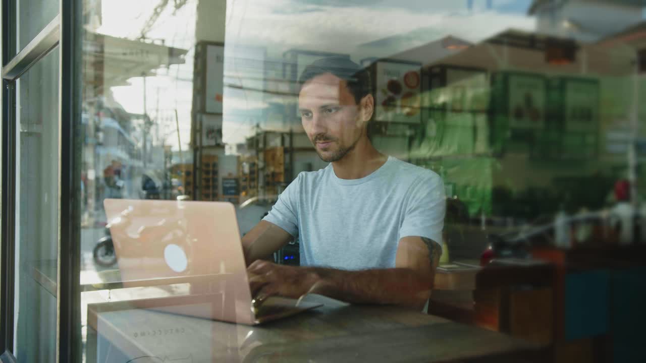 hombre trabajando en una computadora portátil en un café