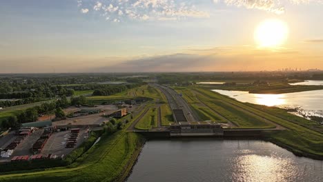 Timelapse-Aéreo,-Puesta-De-Sol-Dorada,-Autopista-De-Transporte-Holandesa,-Agua-Del-Río