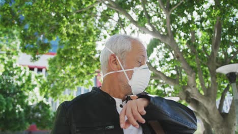 caucasian man out and about in the street wearing on a face mask against coronavirus