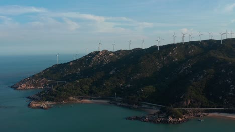 Granja-De-Generadores-De-Viento-En-La-Cima-De-La-Cresta-De-La-Montaña-Junto-Al-Mar-En-Un-Día-Soleado