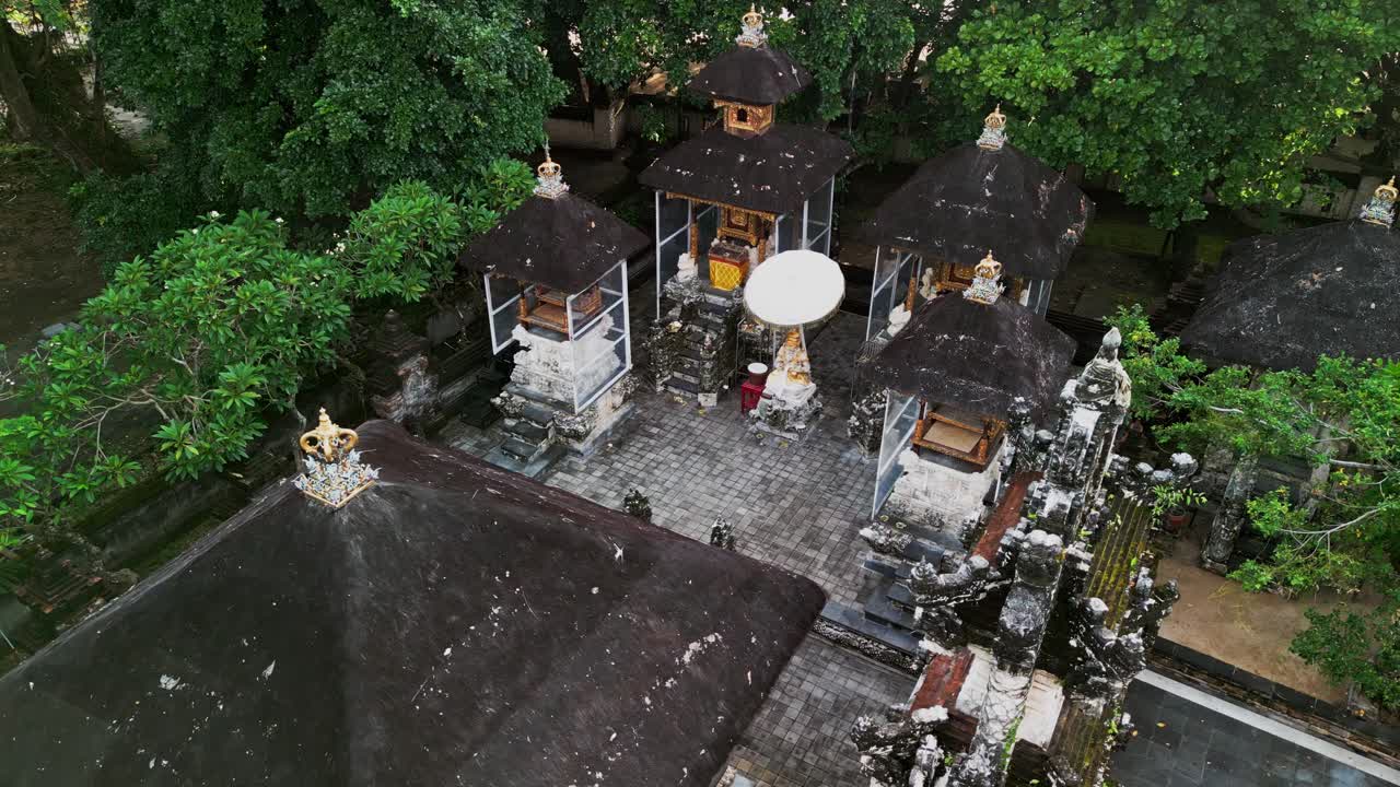 Ubud Bali'de, yemyeşil tropikal bitki örtüsüyle çevrili, süslü türbeleri, antik taş işçiliğini ve huzurlu bir kültürel sığınak yaratan ruhani mirası sergileyen kutsal bir tapınak avlusu