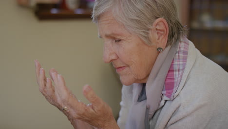 portrait of senior caucasian woman praying looking up hopeful retired elderly female in retirement home