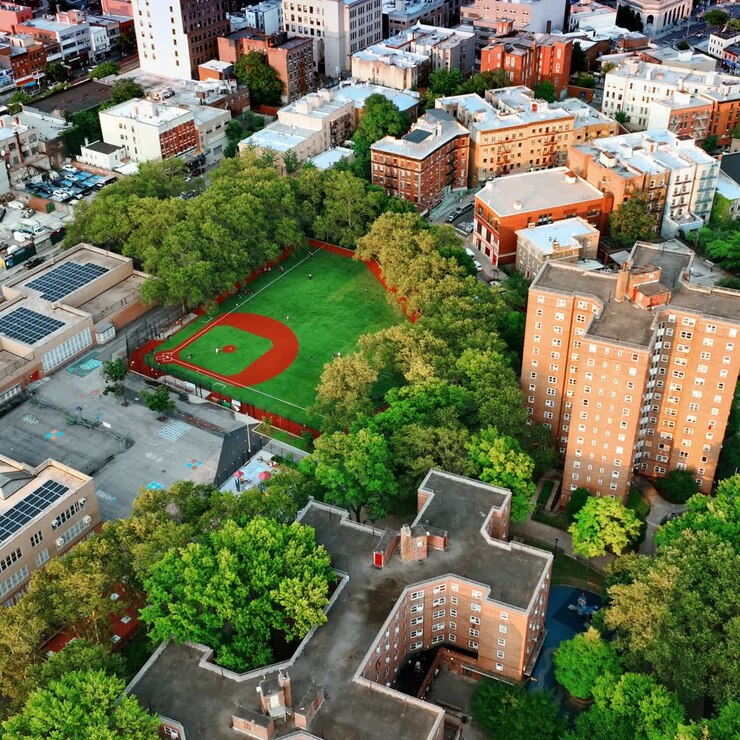 Area residenziale verde con edifici a più piani dal design insolito. Stadio per partite di basket nel quartiere. Panorama di New York. Vista dall'alto