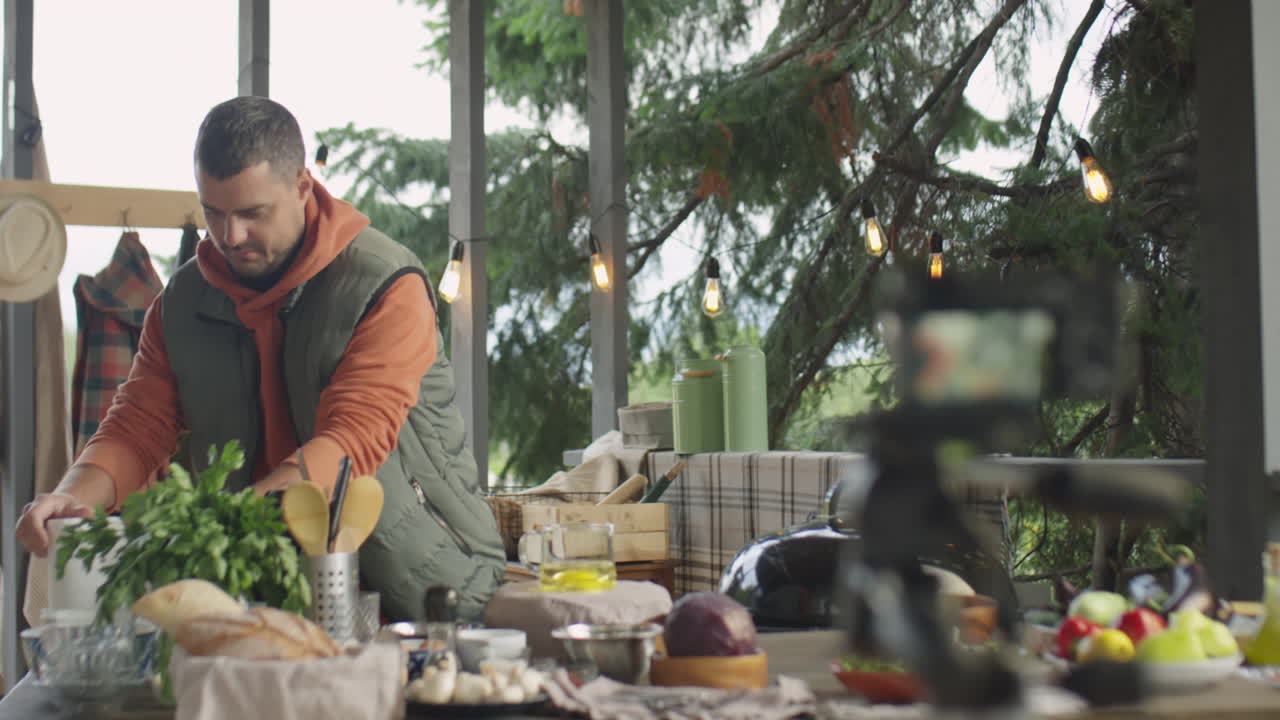 Male Chef Filming Cooking Vlog on Outdoor Terrace