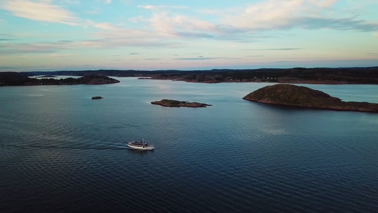 Drone tracking small ferry up and down during sunset