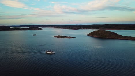 drone tracking small ferry up and down during sunset