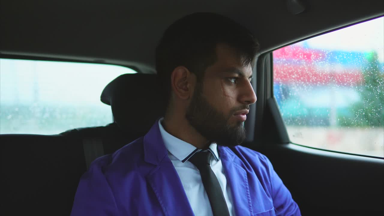 Man in a Purple Jacket Sitting in a Car