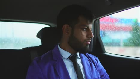 man in a purple jacket sitting in a car