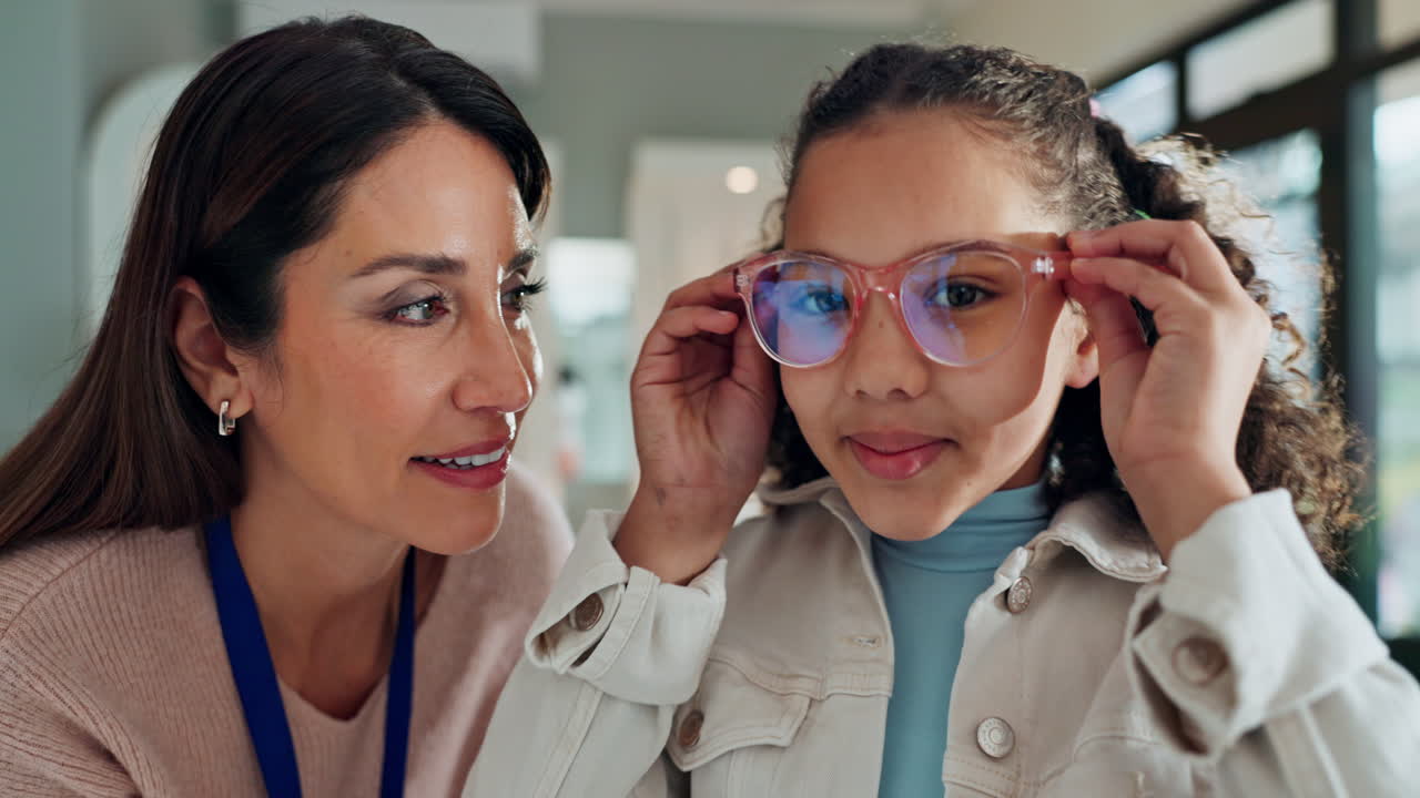 Optician helping a young girl with her eyeglasses