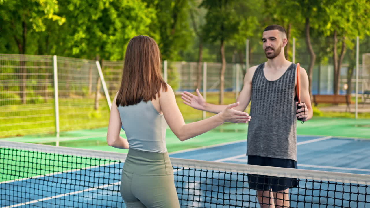 Man and woman doing a secret handshake after playing pickleball after rain