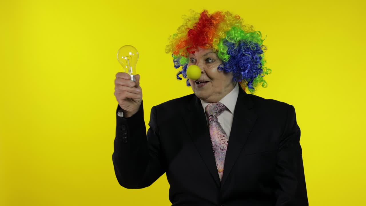 anciana mujer de negocios payaso en peluca espectáculo bombilla. se le ocurrió una gran idea