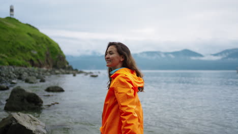 woman in orange jacket at the beach