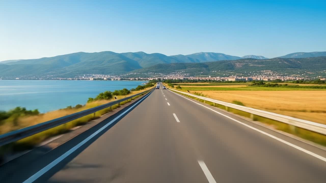 Scenic Road Journey Along Coastal Landscape with Majestic Mountains, Vibrant Fields, and Clear Blue Skies Captured in Two Frames