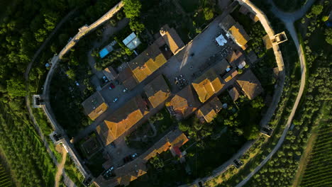 Vista-De-Arriba-Hacia-Abajo-De-La-Pequeña-Ciudad-De-Monteriggioni-En-Medio-De-Un-Paisaje-Verde-En-Toscana,-Italia