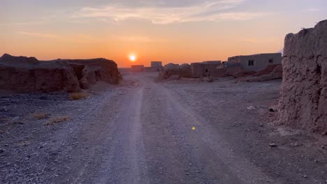 puesta de sol en la carretera del desierto ciudad abandonada en una zona rural remota en el desierto central de irán con clima cálido y seco tiene muchas especies de vida silvestre de oasis y plantas de flora vegetales que viven y crecen junto a manantiales de agua de lluvia
