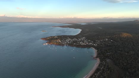 Coles Bay and village along coast at dusk, Tasmania in Australia. Aerial drone panoramic view