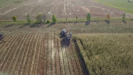 Traktor-Mit-Chaser-Bin-Links-Abbiegen-Auf-Dem-Feld,-Nach-Der-Maisernte,-Luftaufnahme