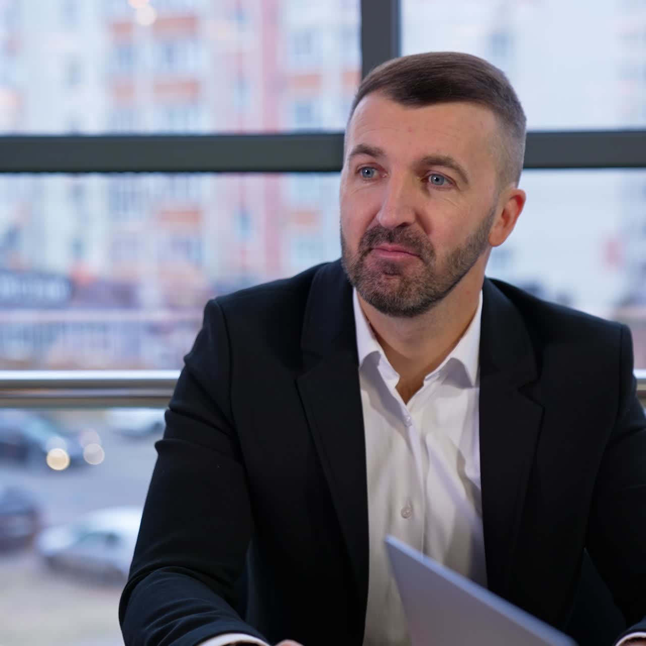 Mid-aged good-looking businessman talks to his employees listening to their ideas. Young long-haired female office worker responding to her boss