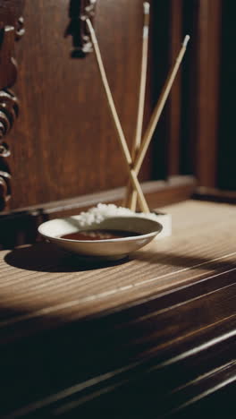 incense sticks and bowl on dark wooden table