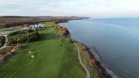 Flug-über-Einen-Golfplatz-Am-Ufer-Eines-Großen-Sees-Im-Herbst