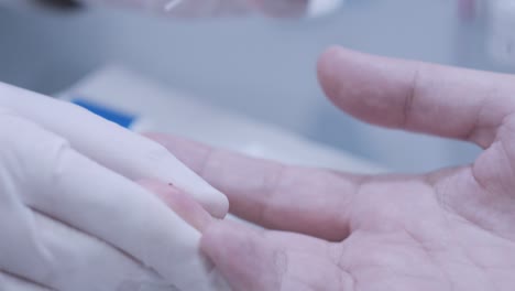 doctor hand take blood test from patient finger at lab. close up of blood test