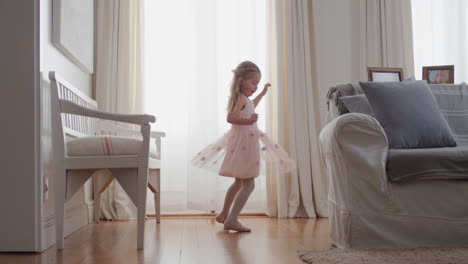 Hermosa-Niña-Bailando-Juguetonamente-Haciéndose-Pasar-Por-Bailarina-Niña-Feliz-Divirtiéndose-Jugando-A-Vestirse-Con-Traje-De-Ballet-Con-Alas-De-Hada-En-Casa-4k