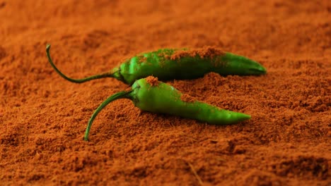 two green chilis sprinkled with powdered paprika orange spices