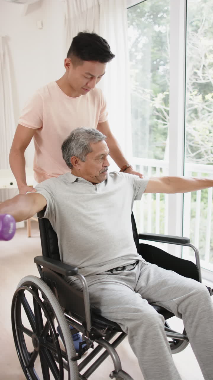 Vertical video of diverse male physiotherapist and senior male patient exercising, in slow motion