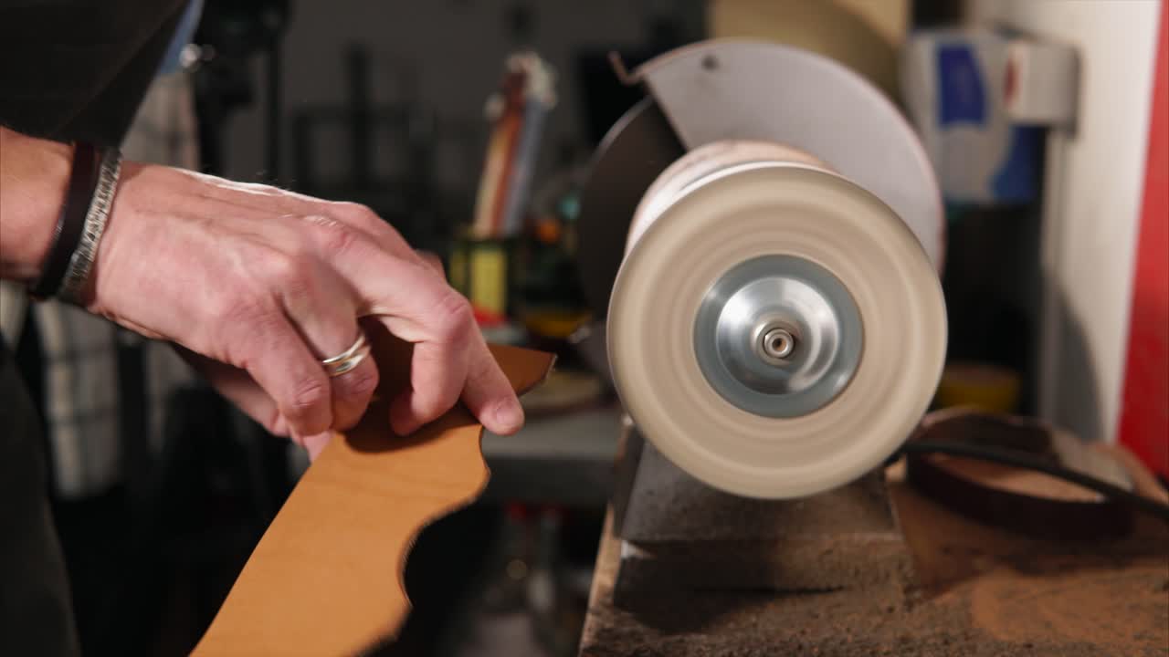 Leatherworking process, polishing a piece of leather with a grinder.