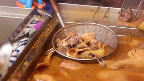 street vendor preparing boiled offal dish