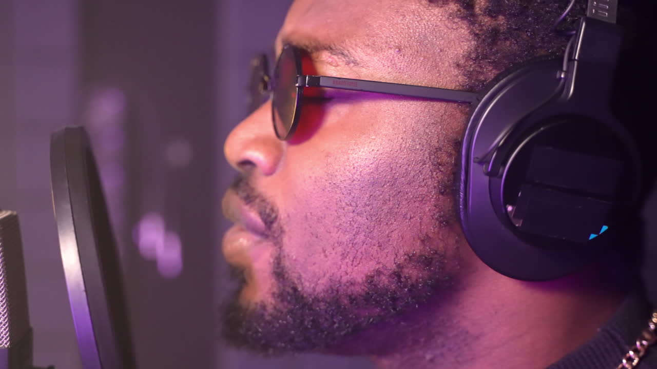 hombre cantando en un micrófono en un estudio de grabación