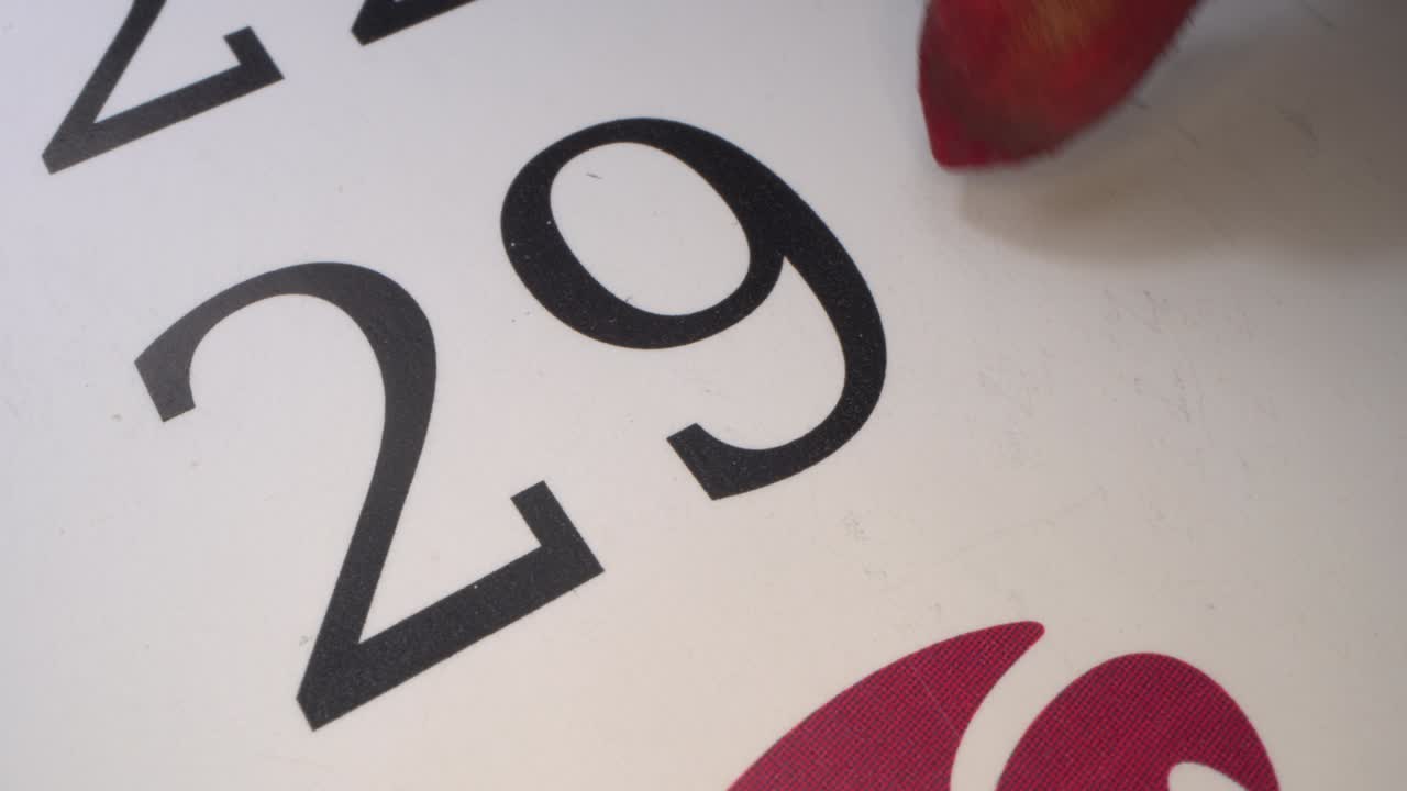 29 - marcando la fecha en el calendario con un marcador rojo. el vigésimo noveno día del mes. plazo