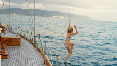 Carefree-young-woman-in-a-bikini-jumping-from-boat