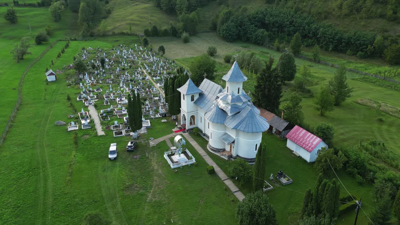루마니아 서부 몰다비아의 바카우 카운티의 팔란카에 있는 역사적인 교회와 초록색 자연을 가진 묘지