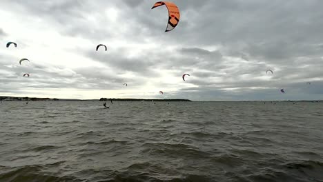 a british harbour full of kitesurfers riding across the scene