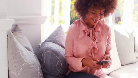 Hermosa-Mujer-Sonriente-Enviando-Mensajes-De-Texto-Por-Teléfono-Celular-Mientras-Toma-Jugo