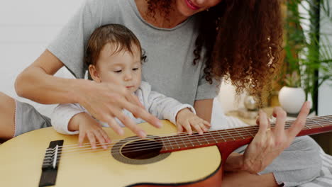 madre y bebé tocando la guitarra por diversión