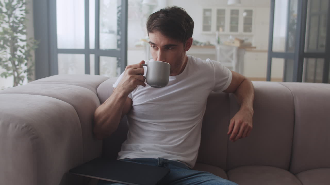 Young businessman drinking coffee in the sofa