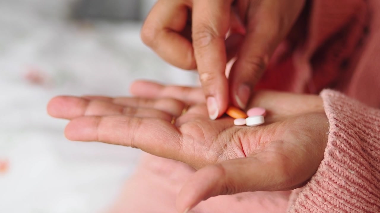 Persona recogiendo medicamento de la palma de la mano
