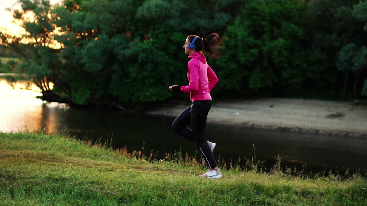 A morning jog in the Park near the pond in the Sunny rays of dawn, the girl is preparing to Mariano and lead a healthy lifestyle