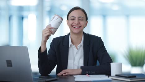 mujer de negocios india que usa el dinero como fan feliz