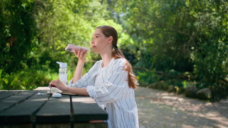 calm woman recording voice message sitting table park closeup. cute girl talking