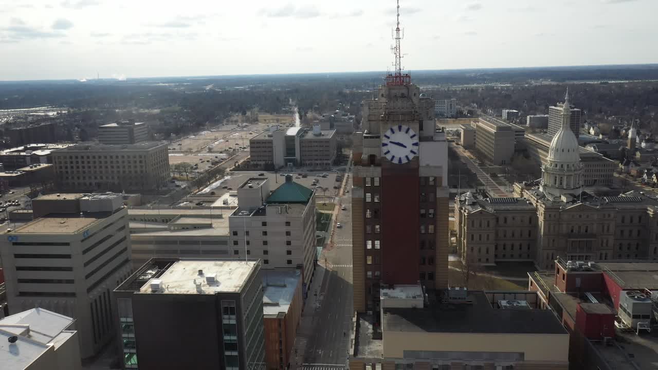 Michigan state capitol building with Boji Tower in Lansing, Michigan. Drone video moving sideways.