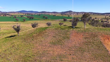 drone flies above rural hill with trees and fields